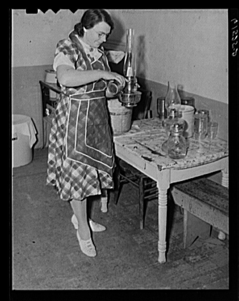 Mrs. Sauer putting oil in lamp, Cavalier County, N.D