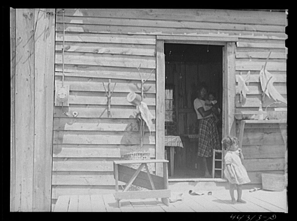 Negro tenant farmer's house showing REA Rural Electrification Administration electric meter on wall.